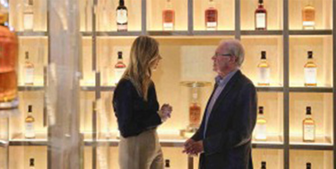 Kelsey and David wall of whisky bottles