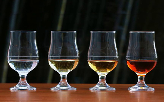 熟成によって色づきの異なる4つの原酒が並んでいる画像：無色透明、薄い黄色、黄色、オレンジ