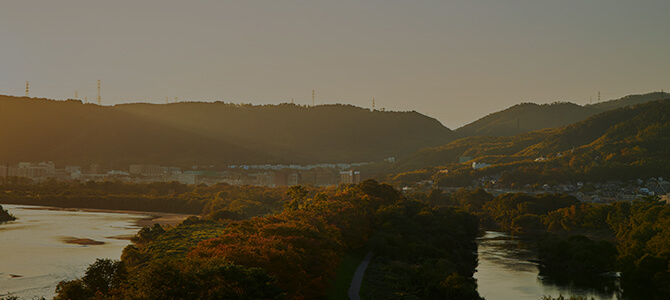 秋の夕日がさす山並みのイメージ