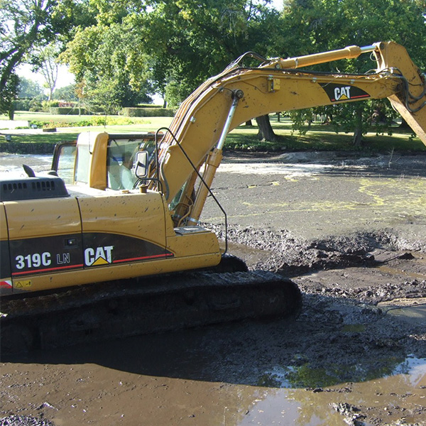 ショベルカーで池底に堆積した土砂を払い出す。
