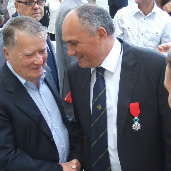 メドックを代表するエノログのボアスノ氏と握手するエイナール社長の胸には赤い勲章が。